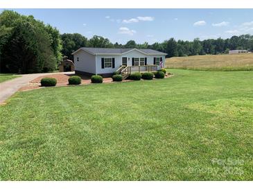 Charming home with a well-manicured lawn, a front porch, and a rustic storage building at 6219 Heavner Rd, Vale, NC 28168