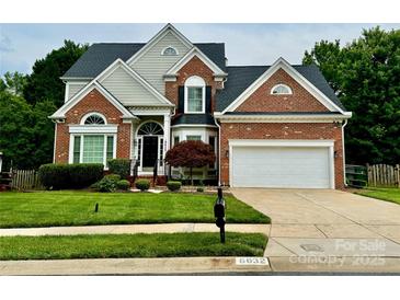 Charming brick home with a well-manicured lawn, attached two-car garage, and inviting front entrance at 6632 Hawksnest Dr, Charlotte, NC 28269