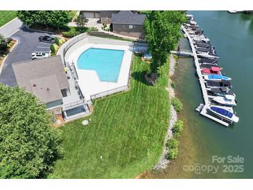Aerial view of a pool, a marina with many boats, and lawn space near the water at 7881 Mariners Pointe Cir, Denver, NC 28037