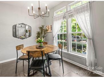 Charming dining area featuring a modern chandelier, oval table, and bright windows at 7881 Mariners Pointe Cir, Denver, NC 28037