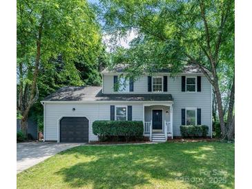 Charming two-story home with a well-manicured lawn, lush greenery, and inviting curb appeal at 9513 Saddle Run Trl, Charlotte, NC 28269
