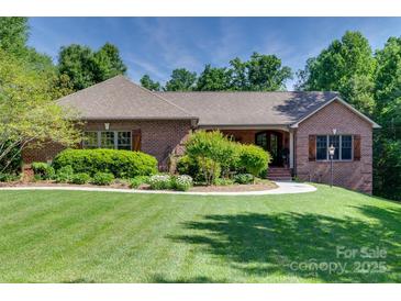 Charming brick home featuring a manicured lawn, lush landscaping, and a welcoming walkway to the front entrance at 103 3Rd Sw St, Catawba, NC 28609