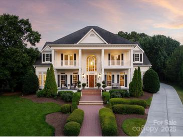 Stunning two-story home featuring classic columns, symmetrical design, and manicured landscaping at 11723 Oakland Hills Pl, Charlotte, NC 28277