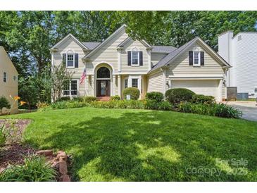 Charming two-story home with a well-manicured lawn and lush landscaping at 12712 Hollyhock Ln, Huntersville, NC 28078