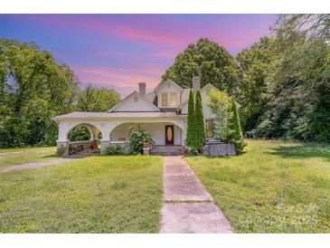 Charming two-story home with landscaped yard and inviting front porch with beautiful color sky at 1637 N College Ave, Newton, NC 28658