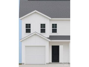 Newly constructed two-story home featuring white siding, black front door and a two car garage at 2735 Primrose Ave, Charlotte, NC 28208