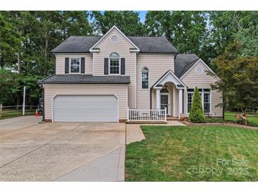 Charming two-story home featuring a well-manicured lawn, two-car garage, and inviting front porch at 107 Glenmont Ct, Mooresville, NC 28117
