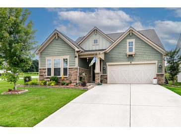 Charming home with a two-car garage, beautiful stone accents, and a well-manicured front yard at 132 Hillston Ln, Mooresville, NC 28115