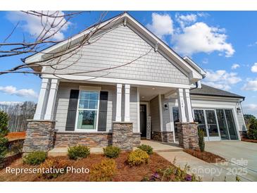 Charming home with stone accents, covered porch, manicured landscaping, and an attached two car garage at 1432 Ardmore Dr # 341, Sherrills Ford, NC 28673