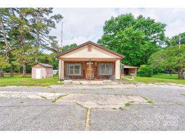 Charming single-story home with a covered front porch and neutral-colored siding, nestled among mature trees at 1529 Stony Point Rd, Shelby, NC 28150