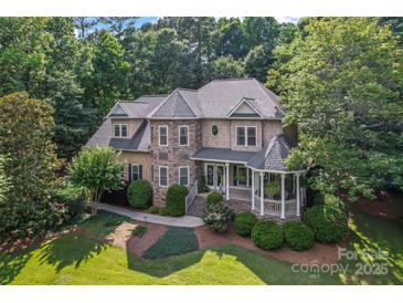 Elegant two-story home boasts stone accents, a welcoming porch, and lush landscaping at 2541 Penngate Dr, Sherrills Ford, NC 28673