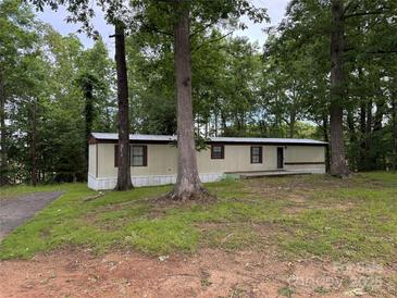 Exterior view of manufactured home with a brown roof, siding, and trees surrounding the home at 326 Havencrest Ct, Gastonia, NC 28052