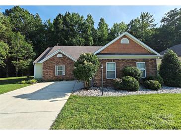 Charming single-story home with brick accents, well-manicured lawn, and mature landscaping at 509 Settlers Grove Ln, Salisbury, NC 28146