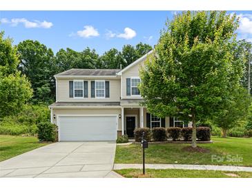 Beautiful home exterior featuring a manicured lawn, mature tree, and two-car garage at 8400 Empress Ct, Charlotte, NC 28227