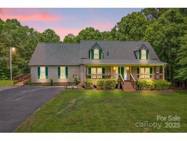 Charming ranch-style home featuring a welcoming front porch, lush lawn, and beautiful landscaping at 8632 Island Point Rd, Sherrills Ford, NC 28673