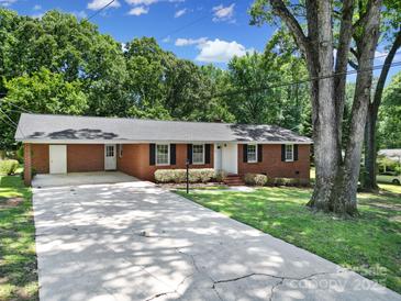 Charming brick ranch-style home with a well-manicured lawn and a long driveway at 967 Hilldale Dr, Lancaster, SC 29720