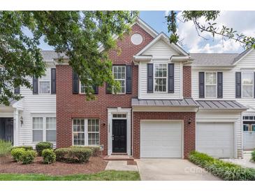 Charming brick and white-paneled townhome with a one-car garage and black shutters at 10225 Alexander Martin Ave, Charlotte, NC 28277