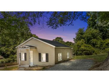 Charming single-story home with neutral siding, black shutters, complemented by lush greenery at 103 Garfield Ave, Albemarle, NC 28001