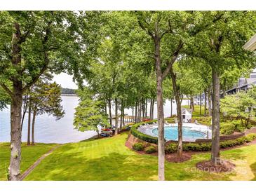 Lakefront community pool and green lawn with mature trees, offering a tranquil lakeside retreat at 303 Northwest Dr, Davidson, NC 28036