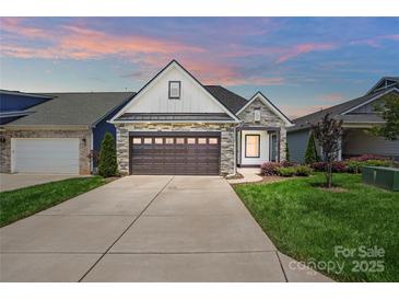 Charming home with a stone and siding exterior, well-manicured lawn, and a two-car garage at 6277 Raven Rock Dr, Denver, NC 28037