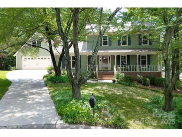 Charming two-story home featuring an inviting front porch and a well-manicured lawn at 9928 Raddington Ln, Charlotte, NC 28269