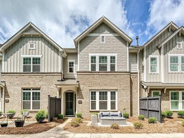 Charming brick townhome with a cozy front patio seating area and well-manicured landscaping at 10022 Wayfair Meadow Ct, Charlotte, NC 28277