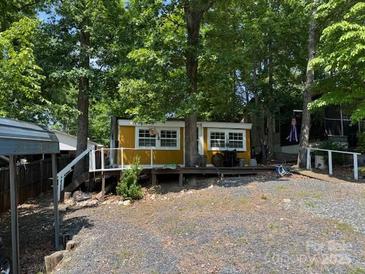 Cozy cabin surrounded by lush trees and greenery, offering a peaceful retreat at 120 Starboard Trl, Mount Gilead, NC 27306