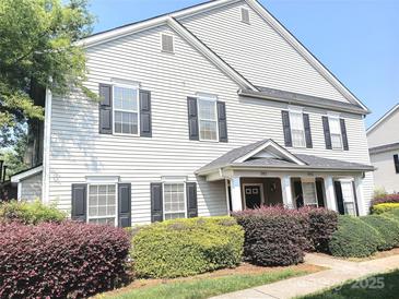 Two-story home featuring black shutters, light gray siding, and manicured landscaping with green and purple bushes at 1911 Flushing Ct, Charlotte, NC 28215
