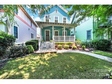 Charming two-story home with a covered front porch, manicured lawn and landscaped garden at 228 Coneflower Pl, Fort Mill, SC 29708