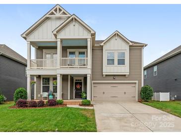 Charming two-story home featuring a covered porch, attached garage, and well-maintained lawn at 4305 Twenty Grand Dr, Indian Trail, NC 28079