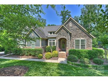 Charming home featuring stone facade, inviting front porch and professionally landscaped front yard at 7916 Deerbridge St, Mint Hill, NC 28227