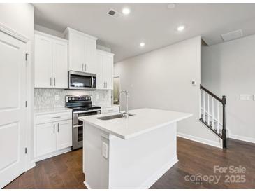 Bright kitchen features an island, stainless steel appliances and white cabinets at 1433 Old Rivers Rd, Concord, NC 28027