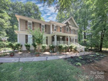 Charming two-story home with a landscaped yard and a mix of stone and beige siding at 155 Culpeze Rd, Mooresville, NC 28117