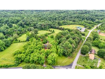 Expansive aerial view of wooded property with lush greenery surrounding a home and nearby buildings at 1783 Radio Station Rd, Newton, NC 28658