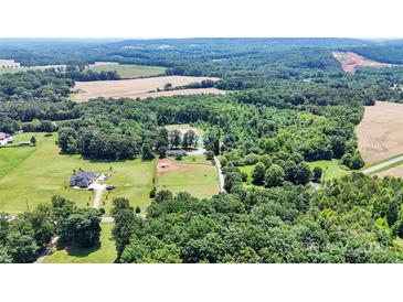 Sprawling property showcasing a home, pond, fields, and lush woodlands in a picturesque aerial shot at 2932 Rant Drum Rd, Maiden, NC 28650