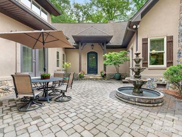 Charming exterior features a beautiful stone patio with fountain and outdoor seating area at 3394 Rainbow Dr, Waxhaw, NC 28173