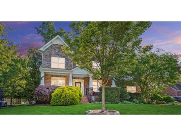 Beautiful two story home boasting stone and brick exterior, front porch, and manicured landscaping at 4009 Oxford Mill Rd, Waxhaw, NC 28173