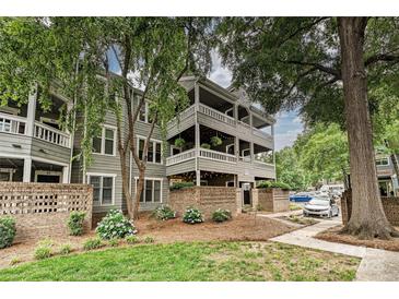 Charming three-story building with a brick facade and inviting landscaped garden with mature trees at 433-68 W 8Th St, Charlotte, NC 28202