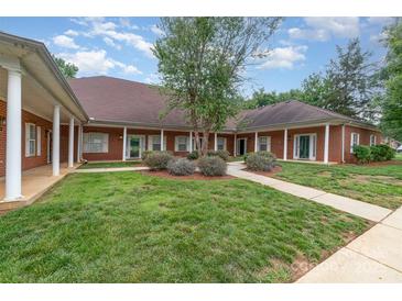 Charming brick home featuring manicured lawn and sidewalk leading to the entrance at 7012 Somerset Springs Dr # E, Charlotte, NC 28262