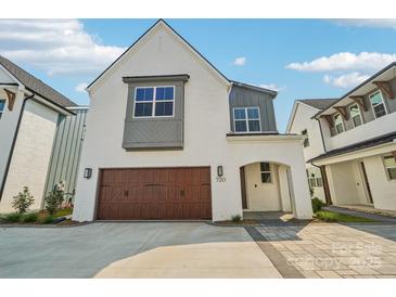 Bright, modern home with a two-car garage and inviting entry way features a beautiful, painted brick facade at 720 Flare Dr, Tega Cay, SC 29708