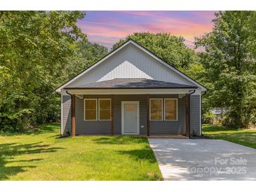 Charming single-story home with gray siding, a covered front porch, and a well-manicured lawn at 925 4Th St, Statesville, NC 28677
