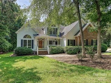 Charming home with a manicured lawn, brick accents and a welcoming front porch lined with manicured shrubs at 12029 Forest Home Dr, Fort Mill, SC 29708