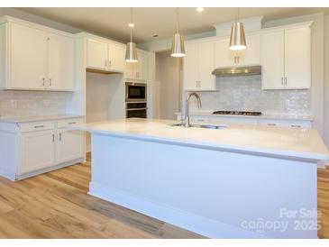 Modern kitchen features a large island, stainless steel appliances, and stylish pendant lighting at 123 Armstrong Rd, Belmont, NC 28012