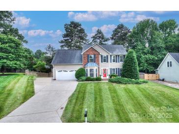 Charming two-story home with a well-manicured lawn, a red front door, and lush landscaping at 1633 Kiawah Ct, Gastonia, NC 28056