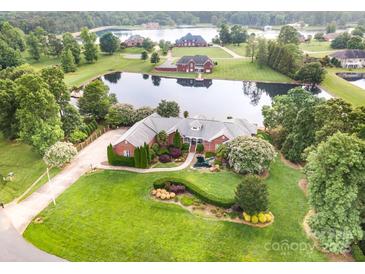 Expansive estate home with a well-manicured lawn, brick exterior and private pond with lake access at 6823 Manatee Dr, Concord, NC 28025