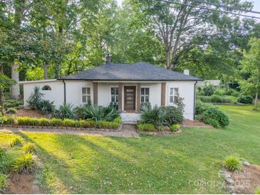 Charming one-story home with brick-lined landscape and a well-manicured lawn nestled among mature trees at 7901 Bud Henderson Rd, Huntersville, NC 28078