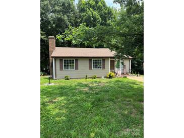 Quaint single-story home with a brick chimney, brown shutters, and a well-manicured lawn at 8019 Walnut Creek Ln, Charlotte, NC 28227