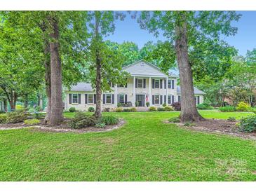 Beautiful two-story white brick home with black shutters and columns, set back on a lush green lawn at 1175 18Th Ne Ave, Hickory, NC 28601