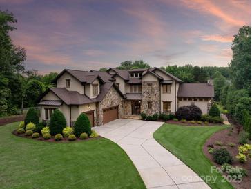 Stunning home with stone accents, lush landscaping, and a long driveway leading to a three-car garage at 1501 Alydar Ct, Waxhaw, NC 28173