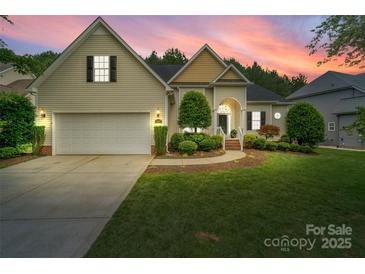 Charming home with a well-manicured lawn, two-car garage, and inviting entrance at dusk at 1653 Shetland Ln, Rock Hill, SC 29730